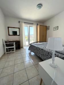 a bedroom with a bed and a table with a lamp at Central Studio Apartments & Dormitory Rooms in Supetar