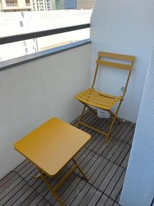 a yellow bench and a chair on a balcony at Eleven by Warren Collection in Sliema