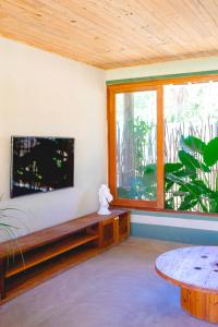 a living room with a flat screen tv and a table at Pousada Rancho Luar in Pôrto de Pedras