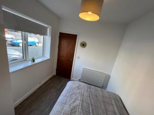 a bedroom with a bed and a window at A spacious flat in Cardiff