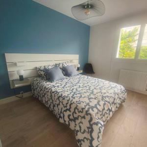 a bedroom with a large bed with a blue wall at Entre ville et vignes 5 min Zenith Grande Halle Auvergne in Romagnat