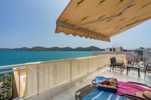 uma varanda com vista para o oceano e uma mesa em The Island em Elounda