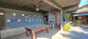 a ping pong table in a patio with a pool table at Pousada Cheiro de Mato in Penedo