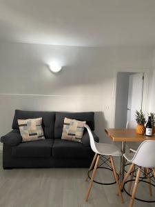 uma sala de estar com um sofá preto e uma mesa em Las Vistas em Jerez de la Frontera