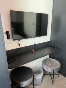 a desk with a tv and two stools in a room at Eleven by Warren Collection in Sliema