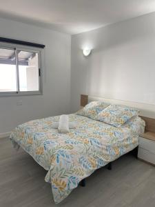 1 dormitorio con cama con edredón y ventana en Las Vistas en Frontera