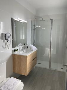 een witte badkamer met een douche en een wastafel bij Las Vistas in Frontera