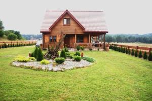 a log cabin in the middle of a field at Najtańsze domki na Mazurach rezerwuj taniej tel 512-29O-43O rezerwacje tylko telefonicznie in Krutyń