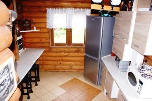 a kitchen with a refrigerator in a wooden kitchen at Najtańsze domki na Mazurach Krutyń Giżycko Mikołajki Mrągowo Ostróda rezerwacje wyłącznie telefonicznie 512-29O-43O prosimy nie sugerować się dostępnością domków na tej stronie zapraszamy www domkiwkrutyni com in Krutyń