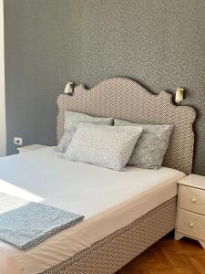 a bedroom with a bed with a headboard and pillows at Super Center in Stara Zagora