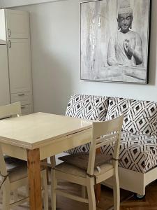 a dining room table and chairs with a painting on the wall at Super Center in Stara Zagora
