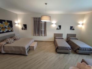 Habitación con 2 camas y sofá en B&B Villa Colomba en Agrigento