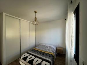 Habitación pequeña con cama y lámpara colgante en Maison en Provence, en Lançon-Provence