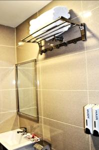 bagno con lavandino e luce sul muro di ECO HOTEL at BB a Kuala Lumpur