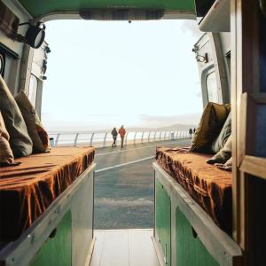 - une vue depuis l'intérieur d'un train donnant sur l'océan dans l'établissement Annie The Ambulance (Drive away campervan), à Skewen