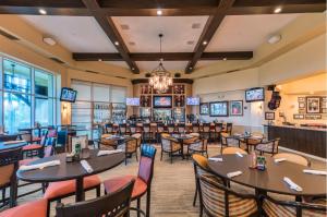 a restaurant with tables and chairs and a bar at Golf Condo- Resort Pool- LakeView- 10mi to beaches in Naples