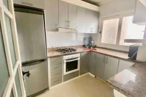 a kitchen with white cabinets and a stove top oven at Bahia del cabo in Cabo Negro