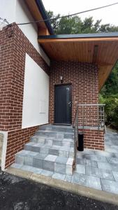 a brick building with a black door and stairs at Penzion Loket in Loket