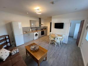 een grote woonkamer met een tafel en een keuken bij A spacious flat in Cardiff