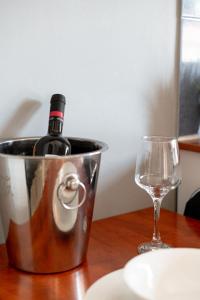 a bottle of wine in a bucket next to a glass at A & D Houses in Patra