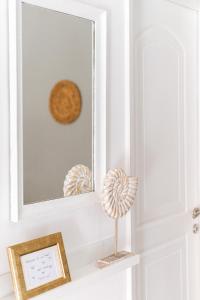 a mirror on a door with a shell on a shelf at A & D Houses in Patra