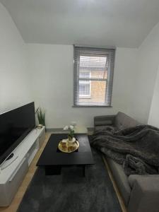 a living room with a couch and a flat screen tv at Two Bedroom Maisonette in Erith in Dartford