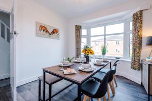 uma sala de jantar com uma mesa e cadeiras e uma janela em Modern 3-Bed house in Stoke by 53 Degrees Property, Ideal for Business & Long Stays - Sleeps 6 em Stoke-on-Trent