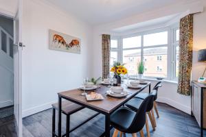 d'une salle à manger avec une table, des chaises et une fenêtre. dans l'établissement Modern 3-Bed house in Stoke by 53 Degrees Property, Ideal for Business & Long Stays - Sleeps 6, à Stoke-on-Trent