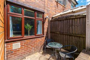 a patio with a table and chairs next to a building at Modern 3-Bed house in Stoke by 53 Degrees Property, Ideal for Business & Long Stays - Sleeps 6 in Stoke on Trent