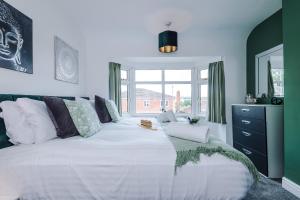 a large white bed in a room with a window at Modern 3-Bed house in Stoke by 53 Degrees Property, Ideal for Business & Long Stays - Sleeps 6 in Stoke on Trent