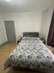 ダートフォードにあるTwo Bedroom Maisonette in Erithのベッドルーム1室(ベッド1台、テーブル2台、ドア付)