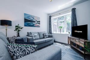 uma sala de estar com um sofá e uma televisão em Modern 3-Bed house in Stoke by 53 Degrees Property, Ideal for Business & Long Stays - Sleeps 6 em Stoke-on-Trent