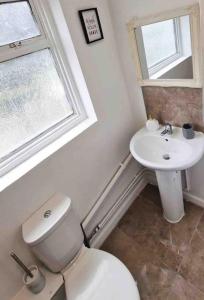 y baño con aseo blanco y lavamanos. en Two Bedroom Maisonette in Erith en Dartford