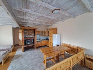 een keuken met een houten tafel en een koelkast bij Akacjowy in Ostrowite