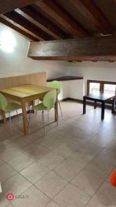 uma sala de jantar com uma mesa e cadeiras verdes em Monolocale Oltretorrente em Parma