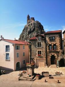 a stone building with a mountain in the background at Au Bon Endroit in Aiguilhe