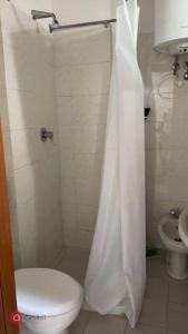 uma casa de banho com um WC e uma cortina de chuveiro em Monolocale Oltretorrente em Parma