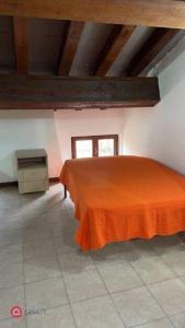 um quarto com uma cama com um lençol laranja em Monolocale Oltretorrente em Parma
