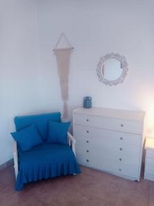a bedroom with a blue chair and a dresser at Welcome Home in Kómi