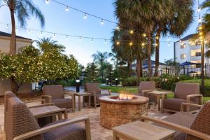 eine Terrasse mit Tischen, Stühlen und einer Feuerstelle in der Unterkunft Courtyard Tampa Westshore/Airport in Tampa