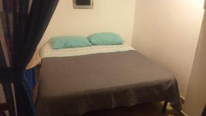 a small bed with two blue pillows on it at Dammuso Primavera in Pantelleria