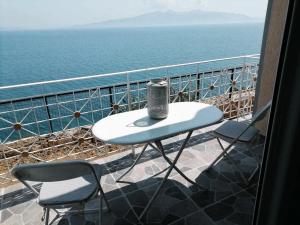 a table and two chairs on a balcony overlooking the ocean at Vila SHAKAJ in Sarandë