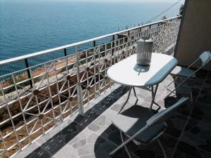 a table and chairs on a balcony overlooking the water at Vila SHAKAJ in Sarandë