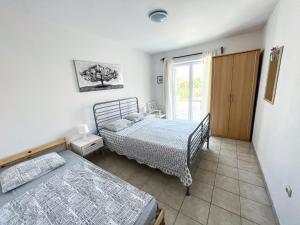 a bedroom with two beds and a window at Central Studio Apartments & Dormitory Rooms in Supetar