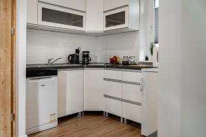 a kitchen with white cabinets and a sink at Apartament Sienkiewicza Centrum in Gniezno