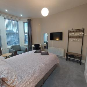 a bedroom with a bed and a flat screen tv at Woodstock Townhouse Belfast in Belfast