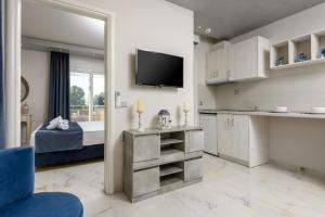 uma cozinha e um quarto com uma cama e uma televisão em Sunny Memories Apartments em Thásos