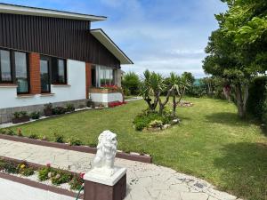 eine weiße Löwenstatue vor einem Haus in der Unterkunft CHALET ENTRE DOS PLAYAS TAPIA in Tapia de Casariego