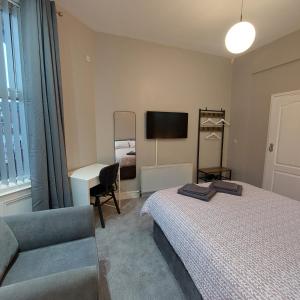 a bedroom with a bed and a chair and a desk at Woodstock Townhouse Belfast in Belfast