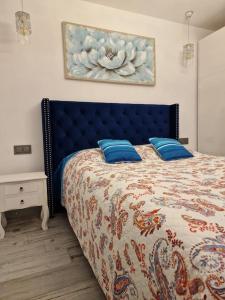 a bedroom with a bed with a blue head board at Cullera Confort Playa in Cullera +32 photos